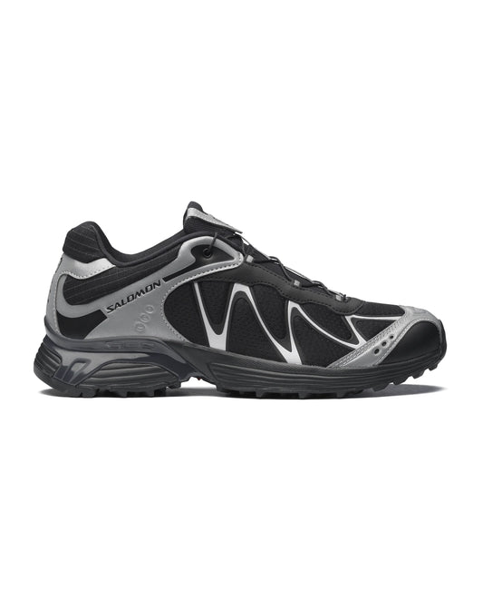 A side view of a Salomon black-and-silver outdoor running shoe, designed for trail and rugged terrain.